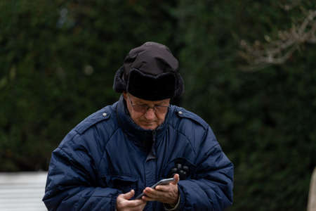 Timisoara, Romania - November 29, 2021: Man checking his phone. Real people on the street.のeditorial素材