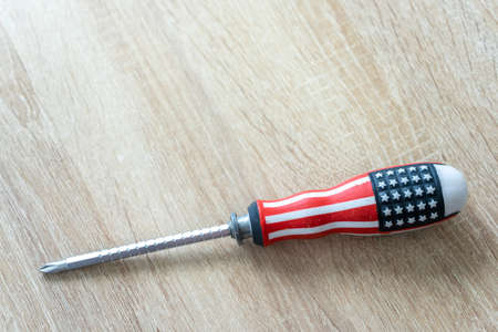 Screwdriver with the american flag on a wooden tableの写真素材