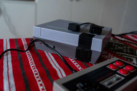 Retro gaming console with classic gamepad controller on a tableの写真素材