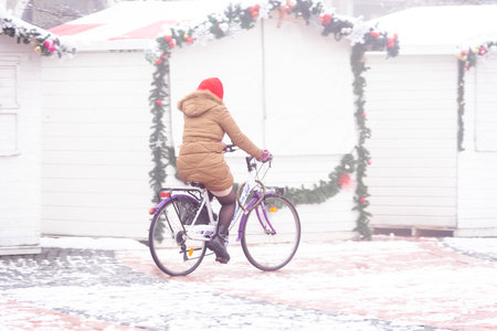 Woman riding her bicycle in the street on a foggy day. Real people.の写真素材