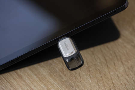 Timisoara, Romania - September 06, 2021: Close-up of a SanDisk flash drive plugged in a tablet