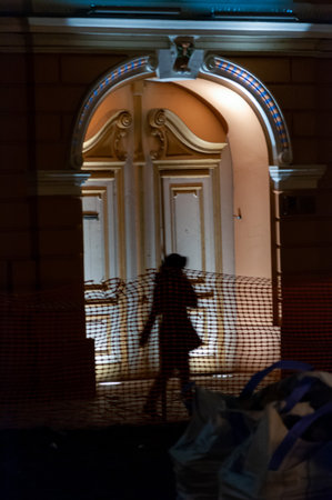 Silhouette of a woman in front of an iluminated door. Night scene.の写真素材