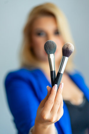 Close-up on a hand holding make-up brushesの写真素材