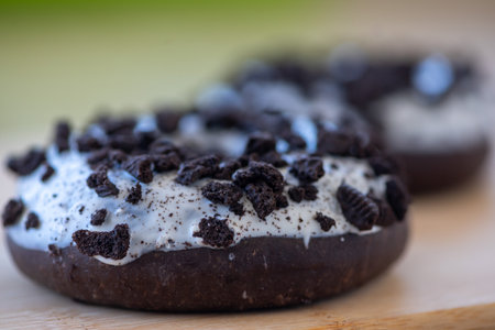 Close-up on brown donuts with white frosting and pieces of cookiesの写真素材