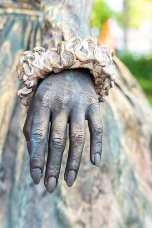 Close-up on the hands of a woman in a masquerade costume posing as a living statueの写真素材
