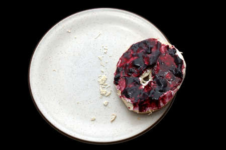 The last bagel half, covered in cheese and jellyの写真素材