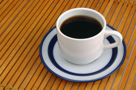 Coffee cup and saucer on wood slat place-matの写真素材