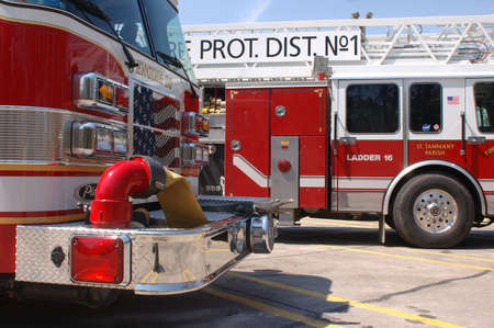 A pair of fire trucks lined up in a parking lot after Katrina. Taken in Slidell, LA, one with the American flag painted on its grillの写真素材