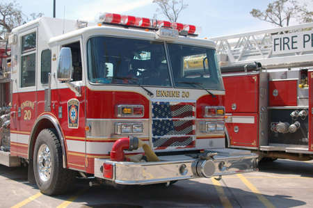 A pair of fire trucks lined up in a parking lot after Katrina. Taken in Slidell, LA, one with the American flag painted on its grillの写真素材