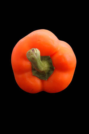A fresh orange bell pepper over blackの写真素材