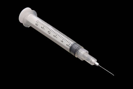A 3cc syringe with a short needle, isolated over blackの写真素材