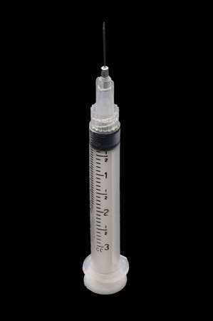 A 3cc syringe with a short needle, isolated over blackの写真素材
