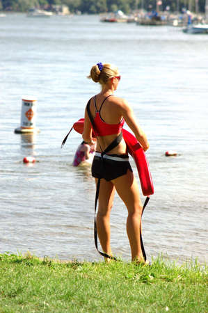Athletic blond lifeguard at a children's beachの写真素材