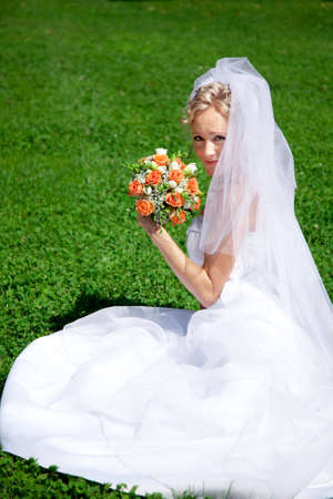 young beautiful  bride with wedding bouquet outdoorの写真素材