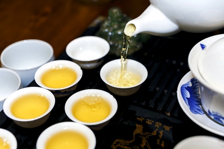A man pours tea during a tea ceremonyの写真素材