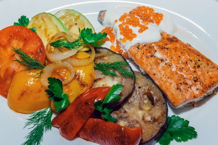 Grilled T-bone steak seasoned with spices and fresh herbs fresh tomato , roast potatoes and red hot chili peppersの写真素材