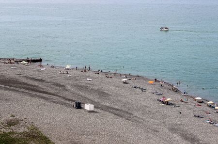 BATUMI, GEORGIA-JULY 3 2015 Tourists are sunning on a pebble beach in Batumi with blue skyのeditorial素材