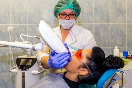 GRODNO, BELARUS-OCTOBER 13,2017. Teeth whitening with UV lamp with photopolymer composition.のeditorial素材