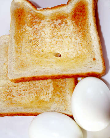 Two hard boiled eggs with buttered toastの写真素材