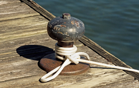 Rope tied to a metal boat slip at dockの写真素材