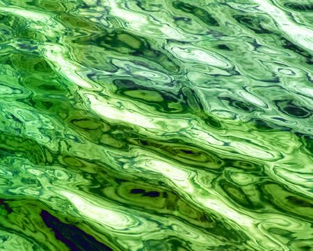 Water surface with soft ripples in shades of emerald greenの写真素材