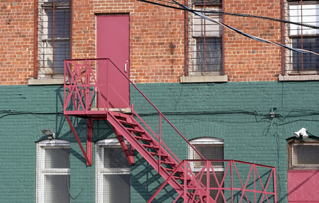 Fire escape and staircase at back of brick buildingの写真素材