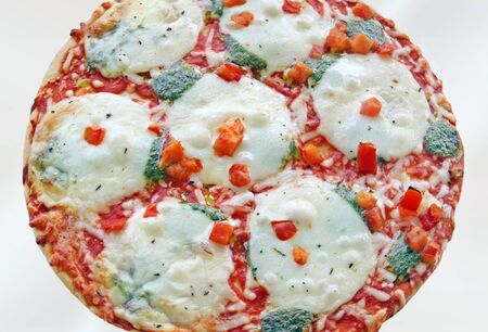 Pizza hot from the oven with melted cheese and veggies.  Isolated on a white background