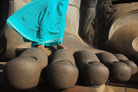 Kanyakumari, Tamil Nadu, India - October 29, 2010: Barefoot woman wearing green dress, stands on  Thiruvalluvar Statue`s feet during a strong windy dayのeditorial素材