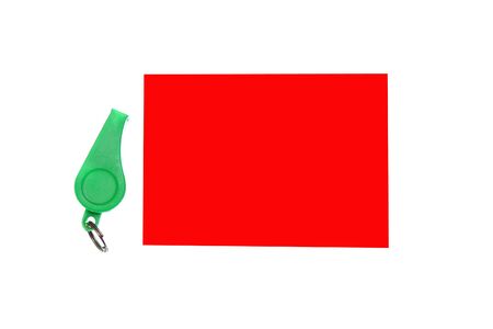 green plastic whistle and red card on white backgroundの写真素材