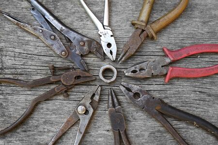 group of vintage pliers teamwork turning nut on board backgroundの写真素材