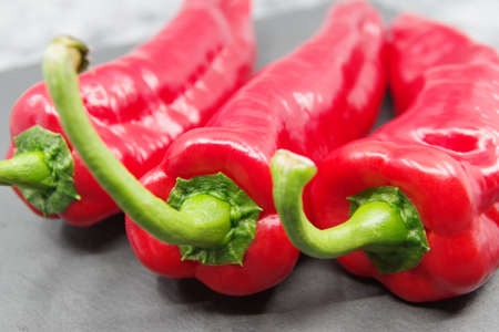 Red sweet peppers on a gray background. Closeupの写真素材