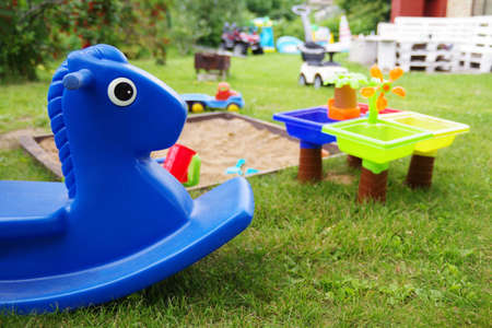 Close-up of children's sandbox in a playground that have a lot of colorful plastic toys for kids