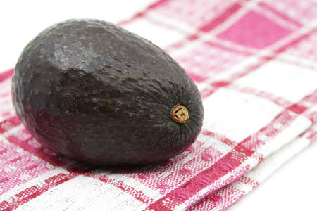 Avocado on a kitchen towel. Avocado fruit isolated on white background. Kitchen towel