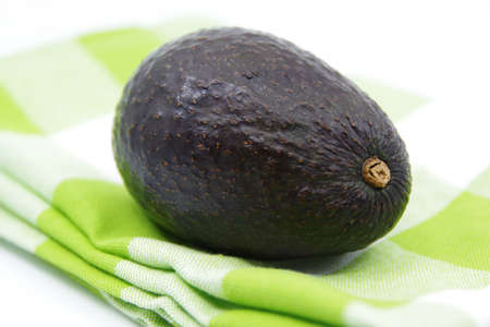 Avocado on a kitchen towel. Avocado fruit isolated on white background. Kitchen towel