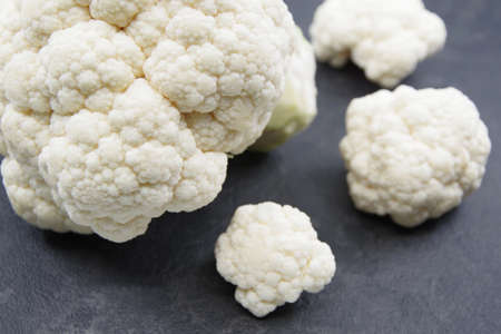 Cauliflower vegetable head on black background. Fresh raw vegan foodの写真素材