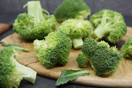 Broccoli for healthy eating. Green fresh broccoli on a wooden cutting board. Organic food preparation. Closeupの写真素材
