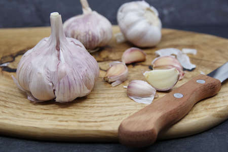 Organic garlic. Fresh garlic cloves and garlic bulb on a wooden cutting board. Garlic for healthy eating. Concept of spices for healthy cooking. Closeupの写真素材