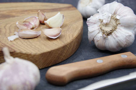Organic garlic. Fresh garlic cloves and garlic bulb on a wooden cutting board. Garlic for healthy eating. Concept of spices for healthy cooking. Closeupの写真素材