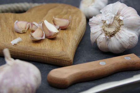 Organic garlic. Fresh garlic cloves and garlic bulb on a wooden cutting board. Garlic for healthy eating. Concept of spices for healthy cooking. Closeupの写真素材