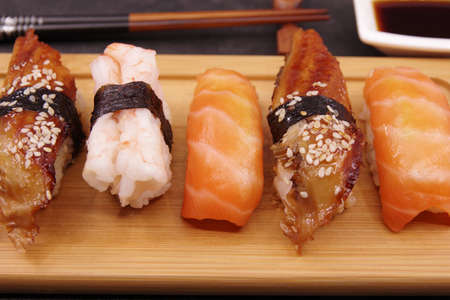 Japanese sushi food on a wooden tray, served with soy sauce. Salmon nigiri, shrimp nigiri, unagi nigiriの写真素材