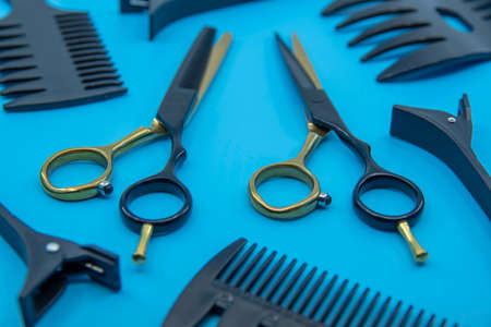 Professional hairdressers tools isolated on blue background. Hairdressers scissor, comb and hairpins.の写真素材