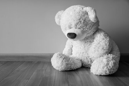 Sad Teddy bear sitting alone on the floor Loneliness and Child abuse concept. Black and white image.の写真素材