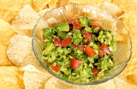 Bowl of Guacamole on a bed of tortilla chipsの写真素材