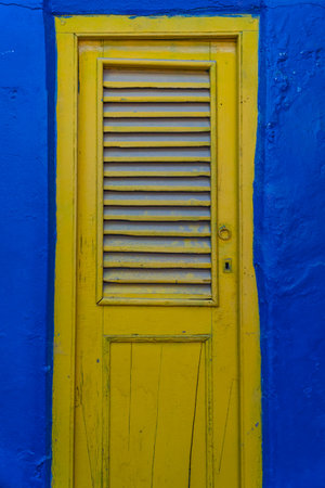 Yellow wooden door on blue wall in the city of Buenos Aires, Argentinaの写真素材