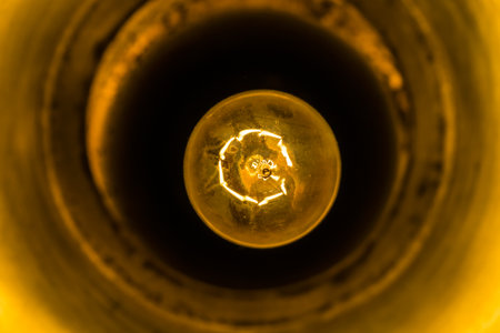 Close up of a lightbulb in a dark room. Abstract background.の写真素材
