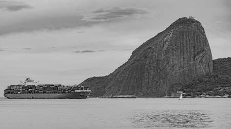 Rio de Janeiro, Brazil - CIRCA 2021: Photo of Sugarloaf Mountain, Sugarloaf Mountain, with a cargo ship passing in front of it in Guanabara Bay during the dayのeditorial素材