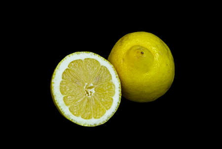 The fruit of a lemon cut in two parts on a black backgroundの写真素材
