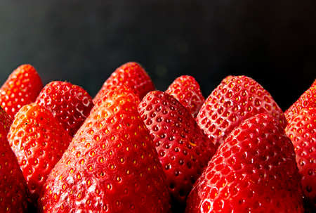Joint of fresh strawberries without leaves on a black backgroundの写真素材