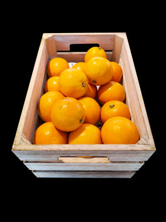 Photograph of a crate of oranges on a black backgroundの写真素材
