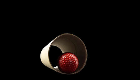 A red golf ball in a cardboard tube on a dark backgroundの写真素材